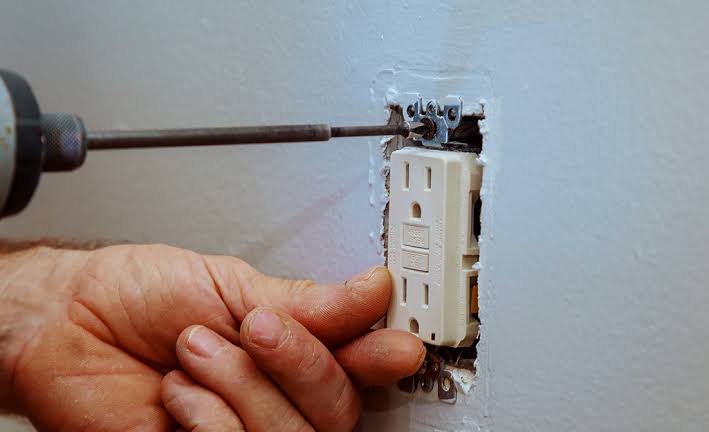Electrician repairing an electrical outlet
